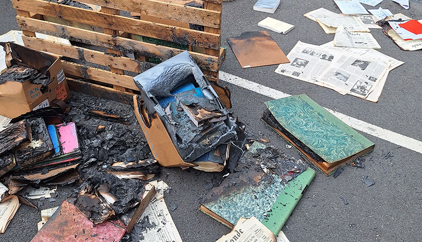 Photo d'objets dégradés par le feu dispersés dans une cour.
